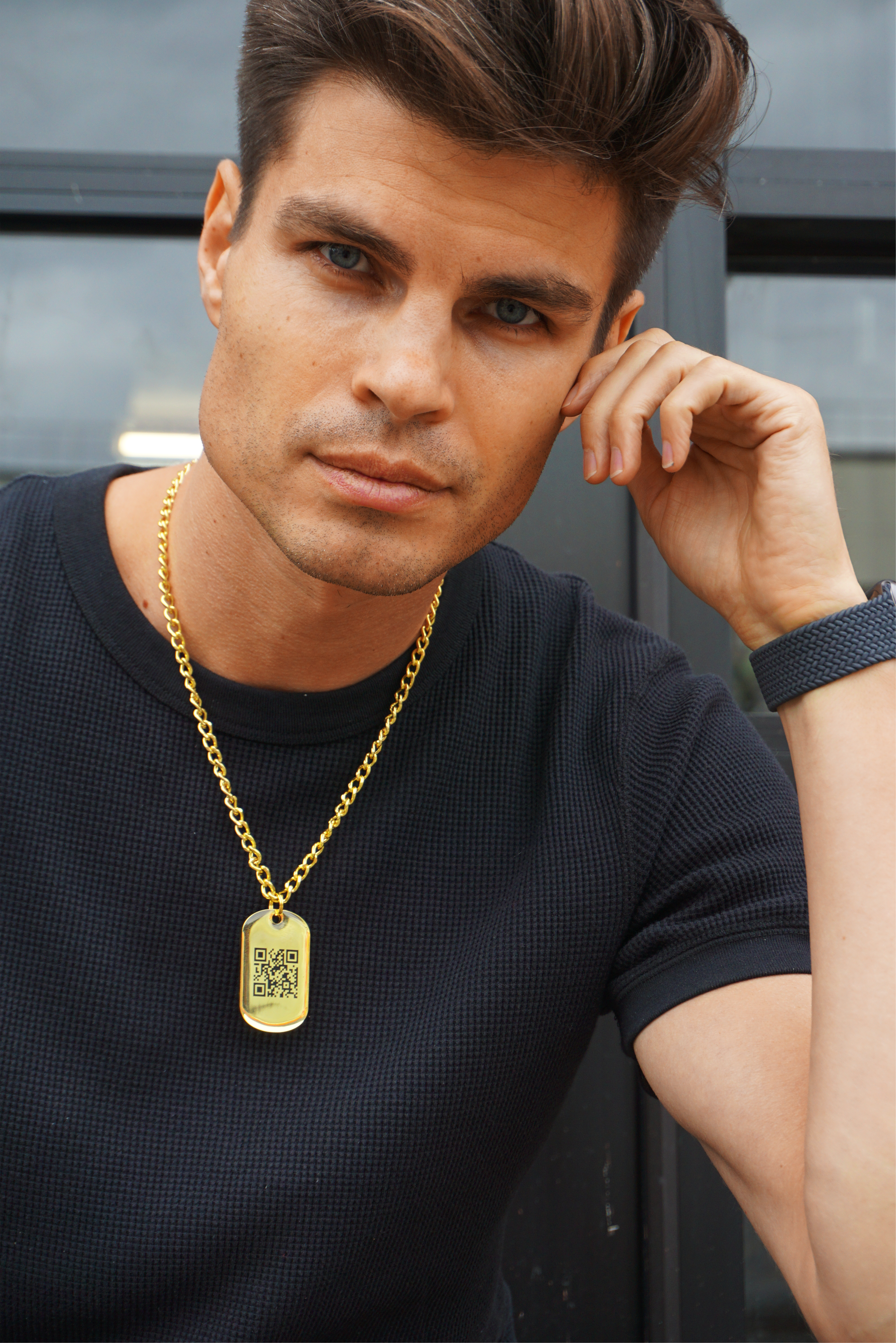 Max Taylor wearing a black shirt & a golden Jumptag QR code necklace